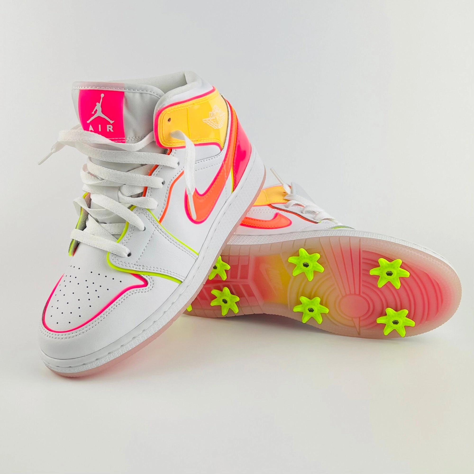 A white and pink Jordan 1 with lime spikes on the sole, finished